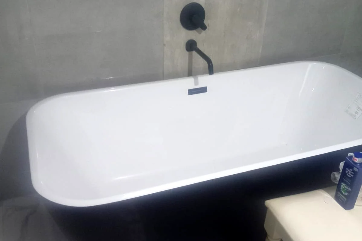 Bathroom with a freestanding bath and wall-mounted bath mixer installed by Sniper Plumbing
