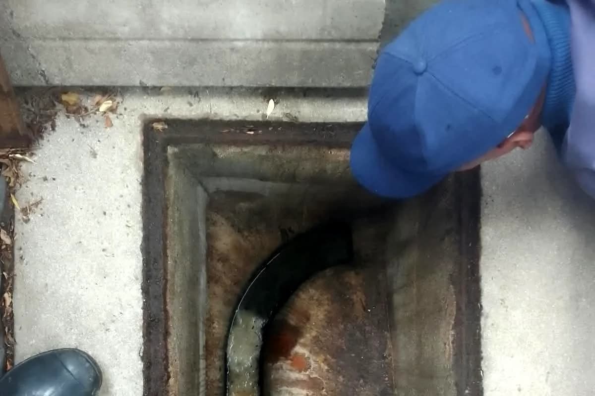 Sniper Plumbing technician at a cleaned-out manhole