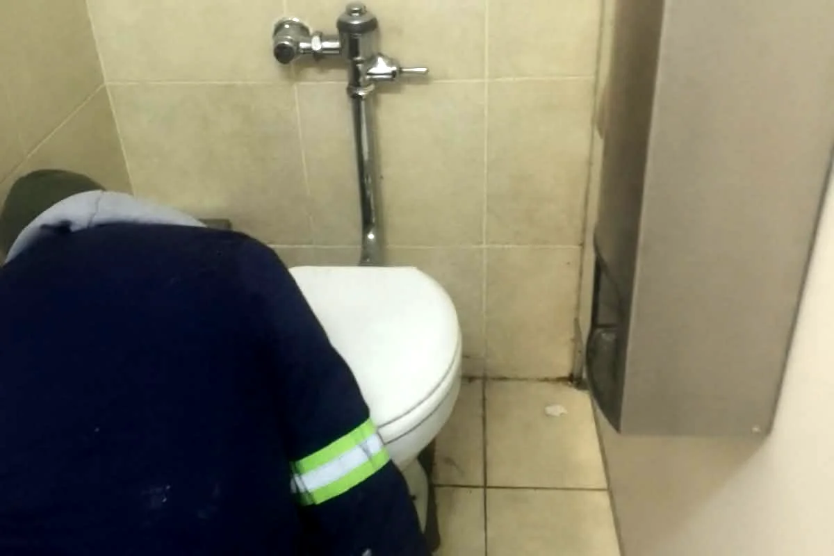 Sniper Plumbing technician repairing a toilet